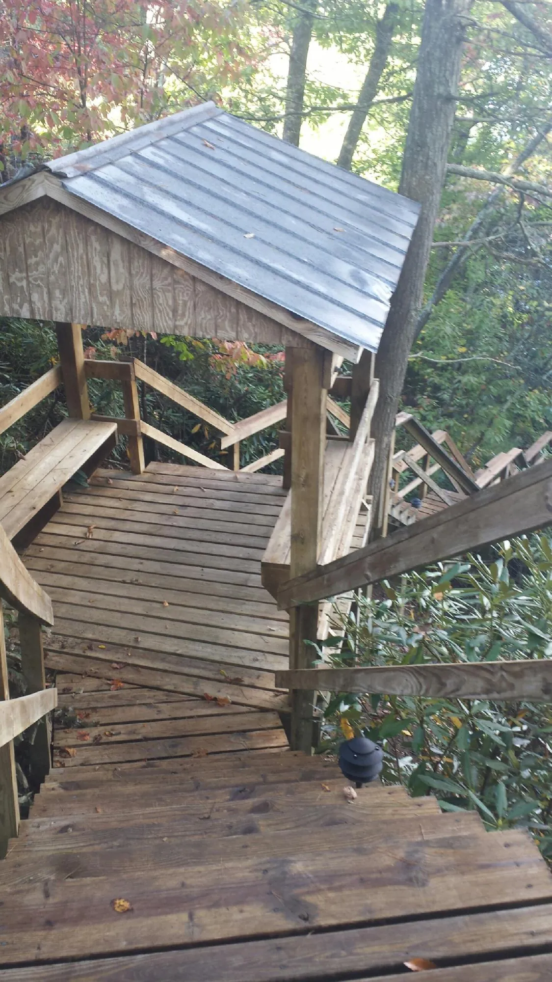 Metal roofed shelter over wooden steps on a wooded walkway — Skylight Repair & Installation work by our crew in Birmingham