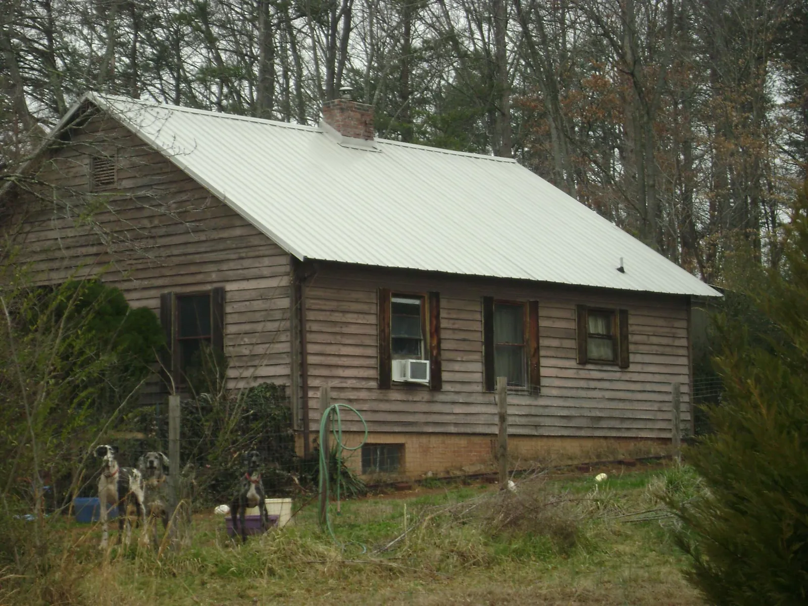 White metal roof on an old wood sided farmhouse, from a Metal Roof Installation job in Birmingham